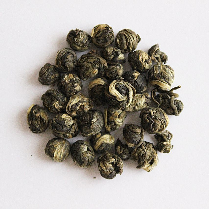 Cluster of green tea jasmine pearls on a white background
